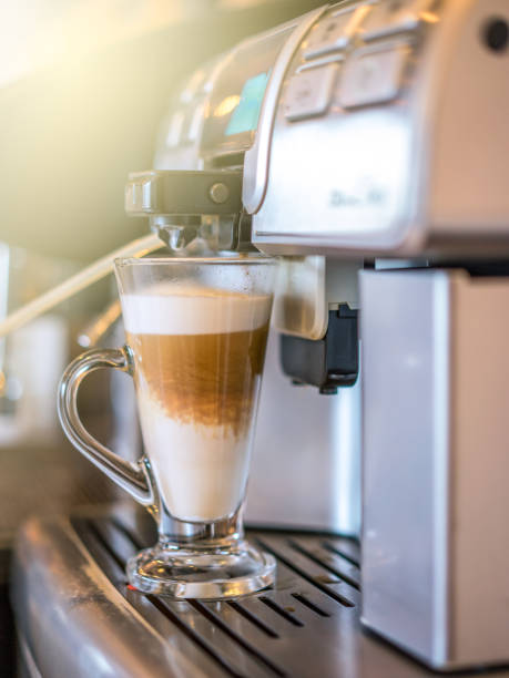 istock Cappuccino coffee being prepared from coffee machine into glass cup. Professional coffee brewing, hot coffee. 969384818