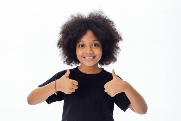 白い背景に分離した親指をあきらめて髪型アフロで愛らしい、陽気なのアフリカ アメリカの子供 - thumbs up child success winning ストックフォトと画像