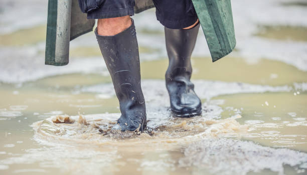 istock A man with black boots walks on a flooded road 969402864