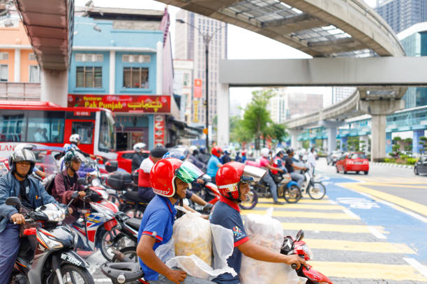 Kuala Lumpur, Malaysia - April 26, 2018: Dozens of motor scooters at a busy intersection in Kuala Lumpur's Chow Kit district. Motor scooters are a popular form or transport in Malaysia.