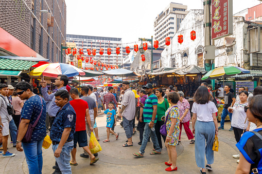 Kuala Lumpur, Malaysia - May 1, 2018: Shoppers filled the vendor-lined Petaling Street in the Chinatown district of Kuala Lumpur, Malaysia. Petaling Street is a world renowned shopping destination that attracts both Malaysians and international visitors in search of street food and bargain goods.