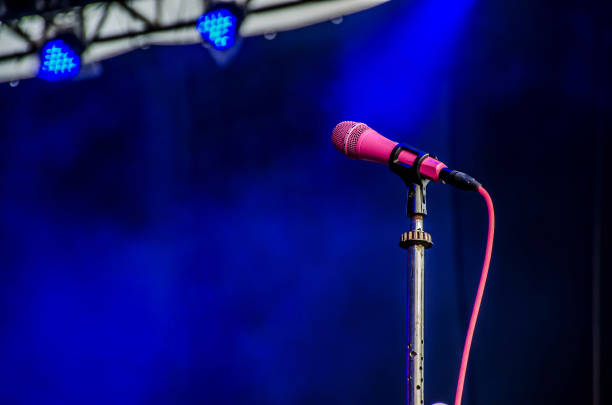 Pink microphone on stage against a background of concert stage