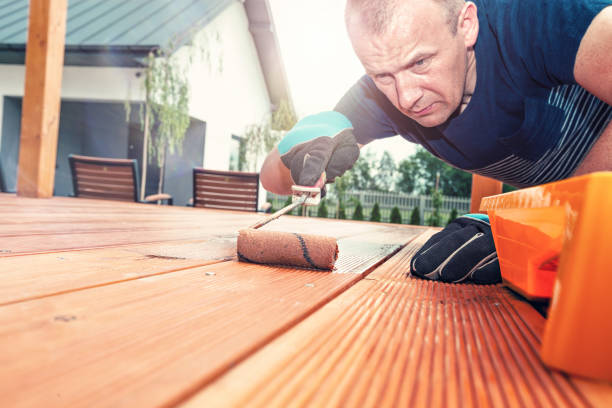 trabajador pinta las juntas en la terraza con un rodillo de pintura - wood deck wood stain paint fotografías e imágenes de stock