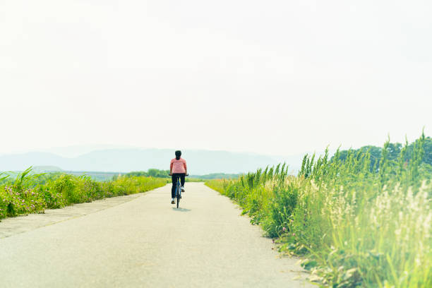 Mid adult japanese woman and bicycle