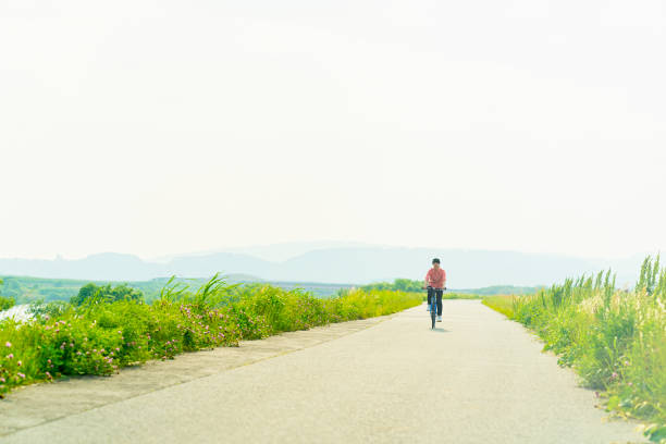 Mid adult japanese woman and bicycle