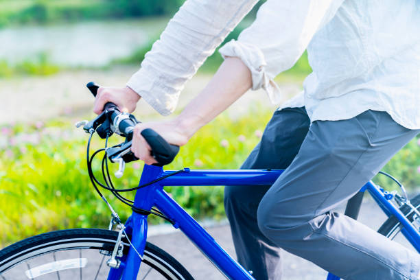 black bicycle pedal on a metal sprocket with a chain on a blue sports bike in green grass on the street