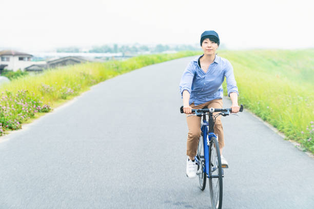 istock Woman riding a bicycle on a road near a river 969439094