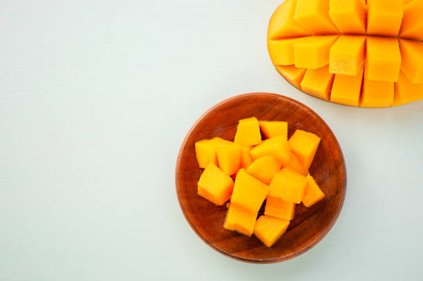 istock Fresh and beautiful mango fruit with sliced diced mango chunks on a light blue background, copy space(text space), blank for text, top view. 969441692