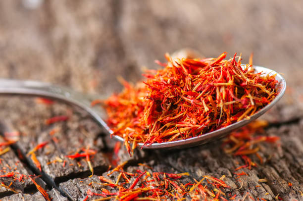 istock Dried saffron spice in a spoon on a wooden background. 969450106