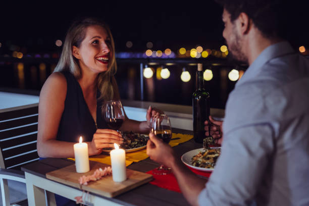 young beautiful couple having romantic dinner on rooftop - dating restaurant dinner couple imagens e fotografias de stock