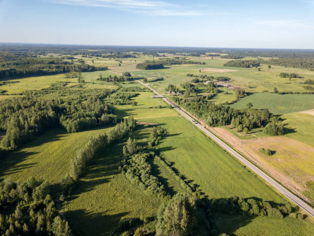 istock drone image. aerial view of countryside road network, cultivated fields and forest textures 969457834