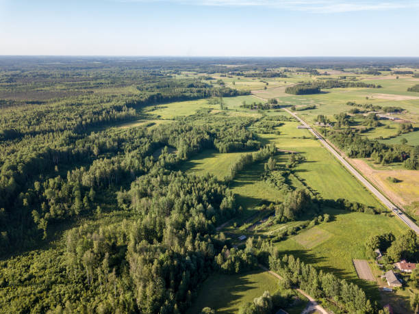 istock drone image. aerial view of countryside road network, cultivated fields and forest textures 969457858
