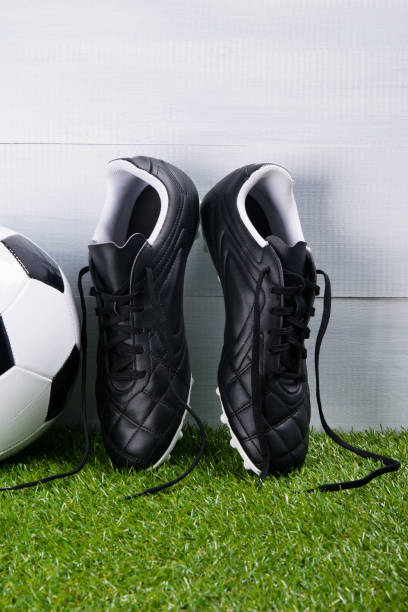istock soccer ball, boots, lying on the grass, on a gray background 969469964