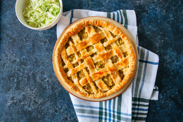 istock Homemade young cabbage pie from flaky dough  served on a plate. Blue stone background. 969477270