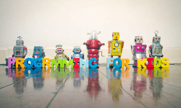 istock PROGRAMMING FOR KIDS with wooden letters and retro robots on a wooden floor 969486366