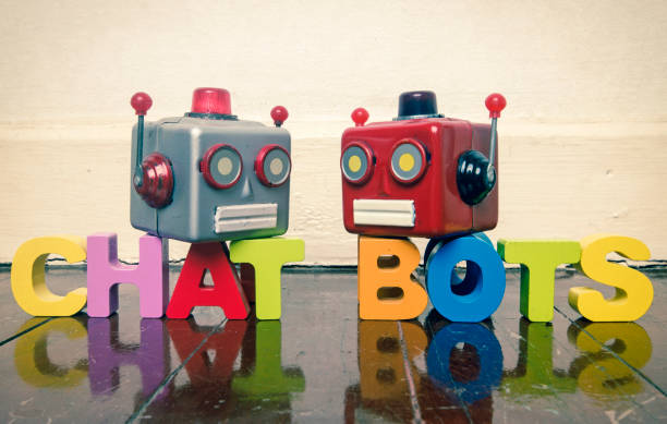 istock two talking heads with the word CHAT BOTS on a wooden floor 969486444