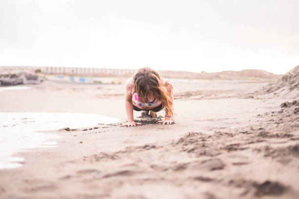 hard plank position on the shore near the ocean waves. nice outdoor sport activity in contact with nature and sand. health body for nice beautiful young woman stay well with fitness. centered position and defocused posición del tablón duro en la costa cerca de las olas del mar. actividad de deporte al aire libre agradable en contacto con la naturaleza y de la arena. cuerpo de salud de bella joven agradable estancia con aptitud. centrado en la posición y desenfocad