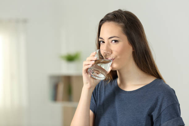istock Woman drinking water and looking at you 969489714