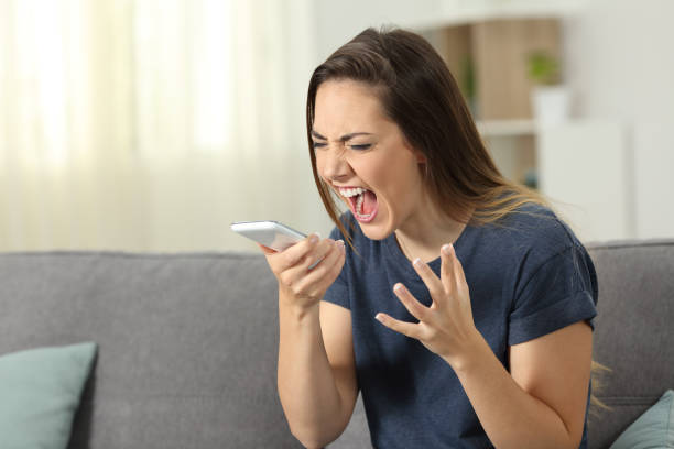 wütende frau schreien zu smartphone zu hause - mobile phone telephone frustration women stock-fotos und bilder
