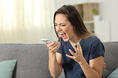 Furious woman shouting to smart phone at home