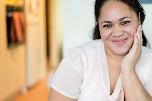 Portrait of happy Maori woman at home, Auckland, New Zealand.