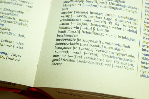 An open old dictionary book on a wooden table