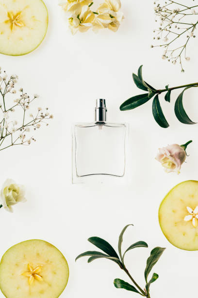 top view of bottle of perfume surrounded with flowers and apple slices on white top view of bottle of perfume surrounded with flowers and apple slices on white green apple slice overhead stock pictures, royalty-free photos & images