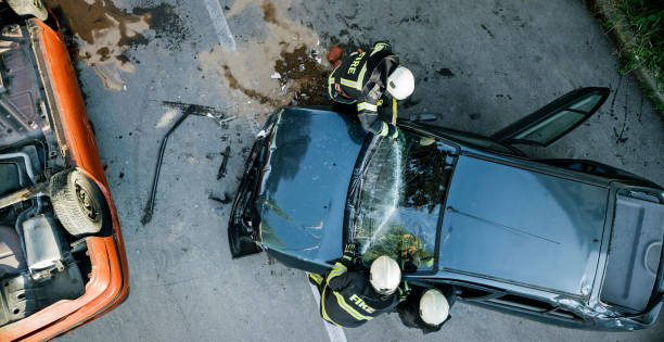 Car accident Firefighters using a glass cutter to cut car windscreen after accident. firefighter photos stock pictures, royalty-free photos & images