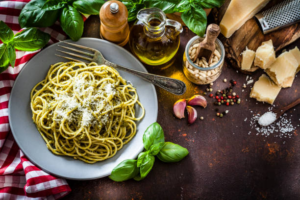 паста аль песто пластины на темном кухонном столе - pesto sauce italian culture pine nut photography стоковые фото и изображения