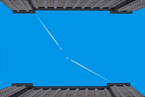 Airplanes leaves trace on clear blue sky  between the two buildings