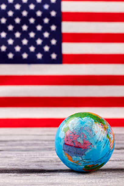 istock Globe on table with USA flag in the background. 969504650