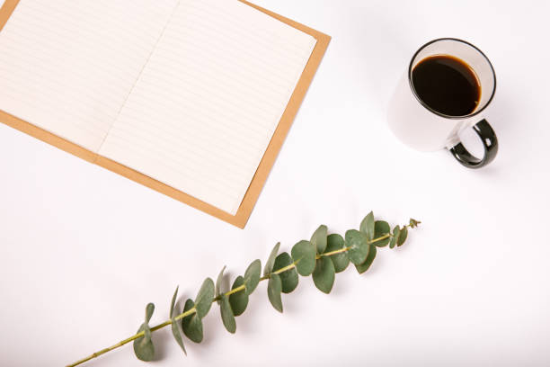 istock Blank notebook cup of coffee  flowers white background 969504860