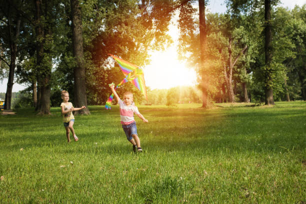 istock Small boy flying kite and running in the park. 969519036