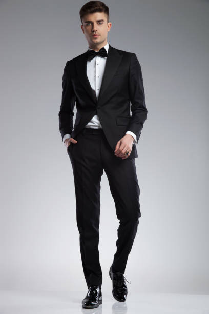 istock relaxed stylish man wearing a black tuxedo walking 969519076