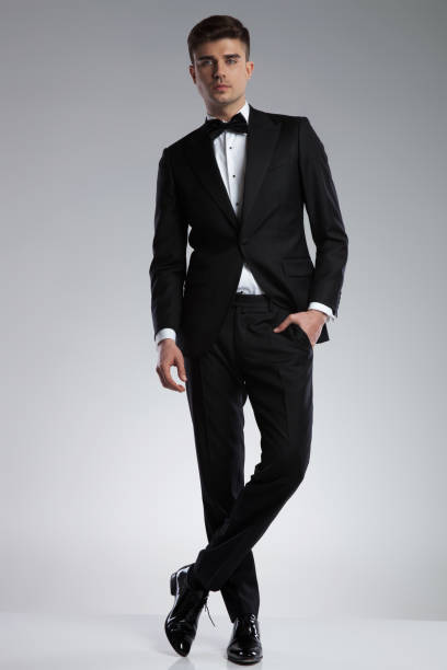 istock relaxed elegant young man standing with legs crossed 969519086