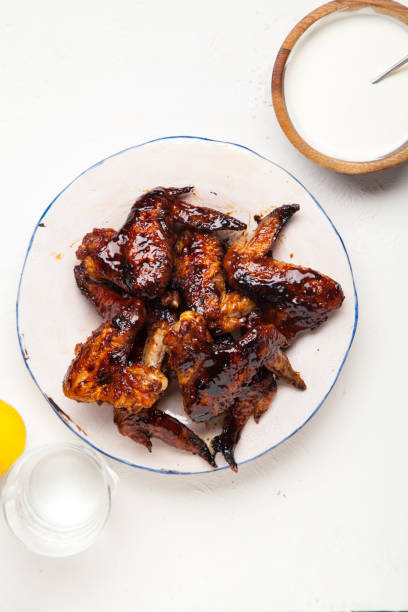 alitas de pollo con dos salsas sobre fondo blanco. concepto de barbacoa de verano. - wing spicy chicken wings chicken sauces fotografías e imágenes de stock