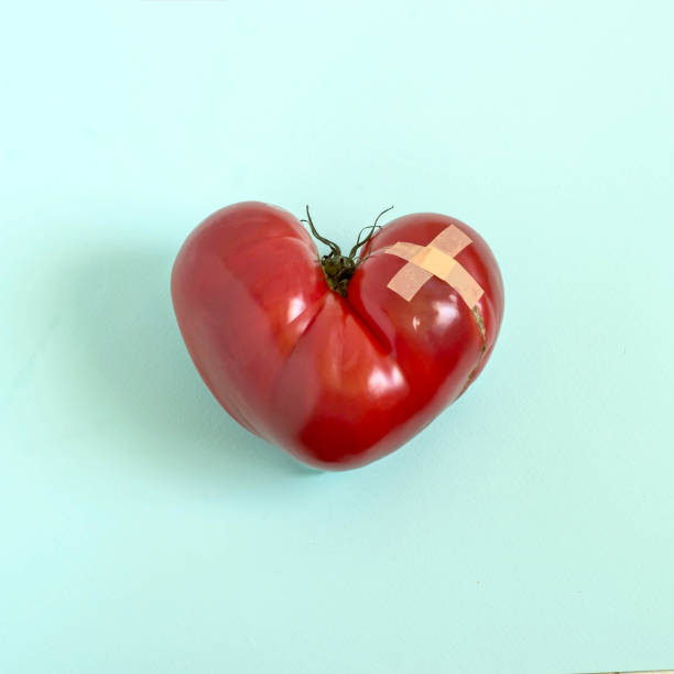 istock Tomato in shape of wounded heart with adhesive plaster 969522564