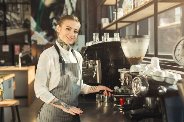 istock Tattooed barista making coffee in professional coffee machine 969528824