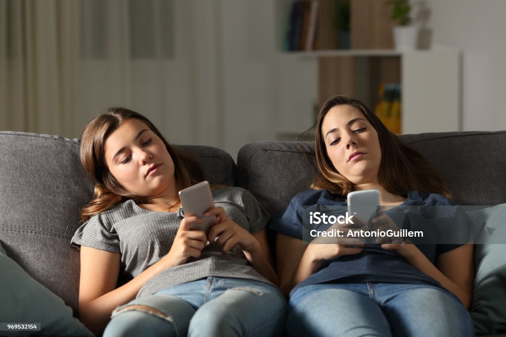 Aburren con sus amigos utilizando sus teléfonos inteligentes - Foto de stock de Adolescente libre de derechos
