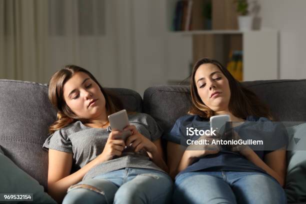 Aburren Con Sus Amigos Utilizando Sus Teléfonos Inteligentes Foto de stock y más banco de imágenes de Adolescente