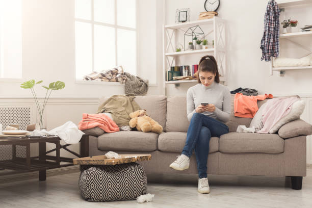istock Desperate woman sitting on sofa in messy room 969532210