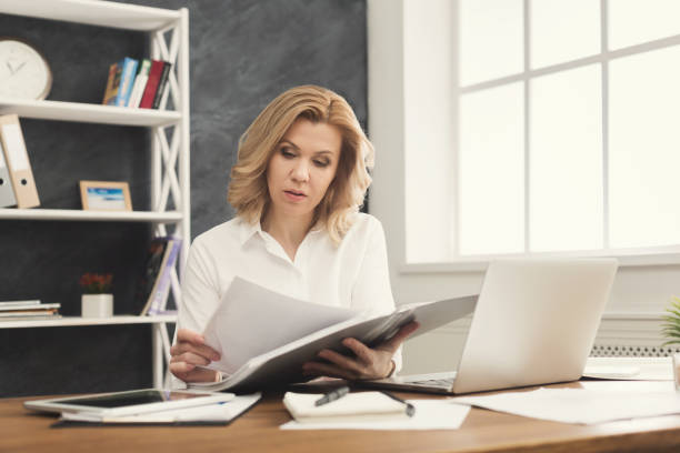 istock Thoughtful businesswoman reading document at office desktop 969535500