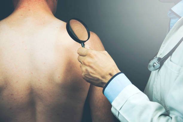 istock doctor with magnifier and man 969539104