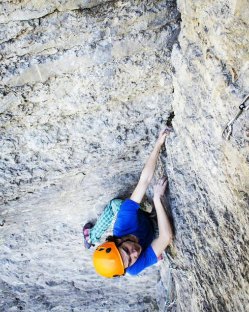 istock Man rock climber. Rock climber climbs on a rocky wall. Man makes hard move. 969539252