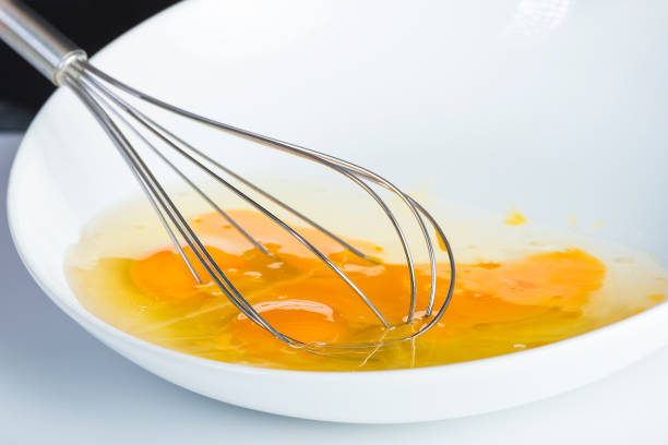 istock Chef beating eggs in a bowl witha a manual mixer 969542144
