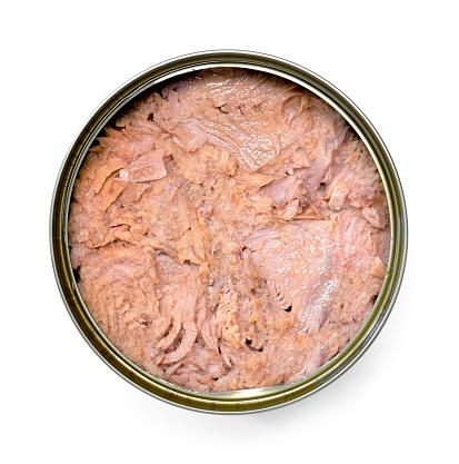 Tuna can, isolated on white background. Top view or high angle shot of conserved tuna fish packed in an opened metal tin.