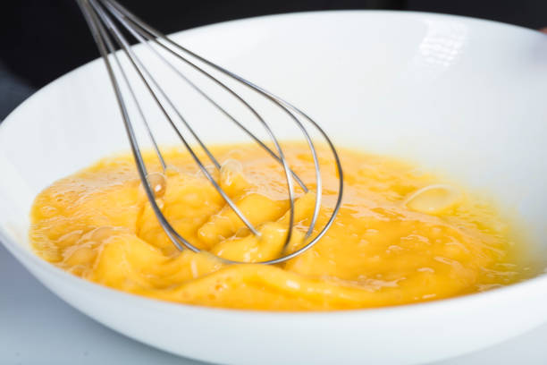 istock Chef beating eggs in a bowl witha a manual mixer 969542742