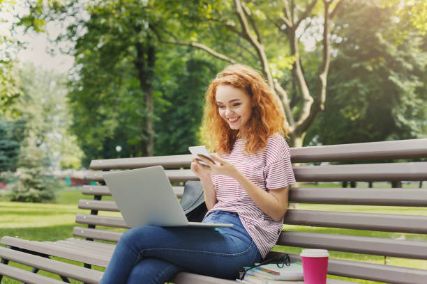 istock Happy woman texting on smartphone in the park 969543290
