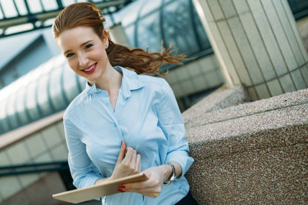 istock Attractive young businesswoman using digital tablet outside 969546830