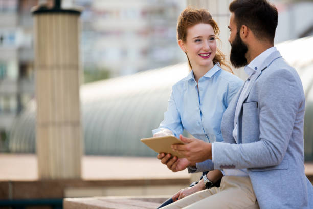 istock Two smiling young business people working on tablet outdoors 969549782